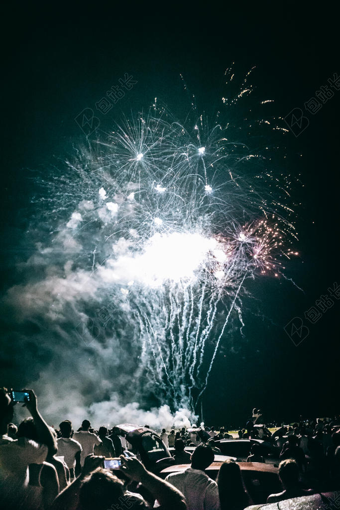 彩色光线人群上空绽放的烟花烟花庆祝人们背景图片