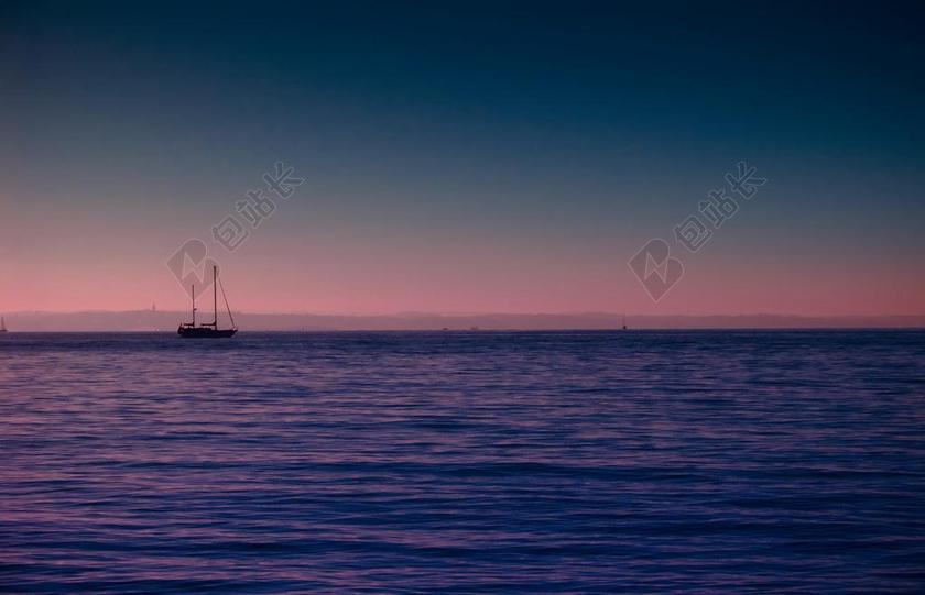 黄昏大海上运去的船背景图片