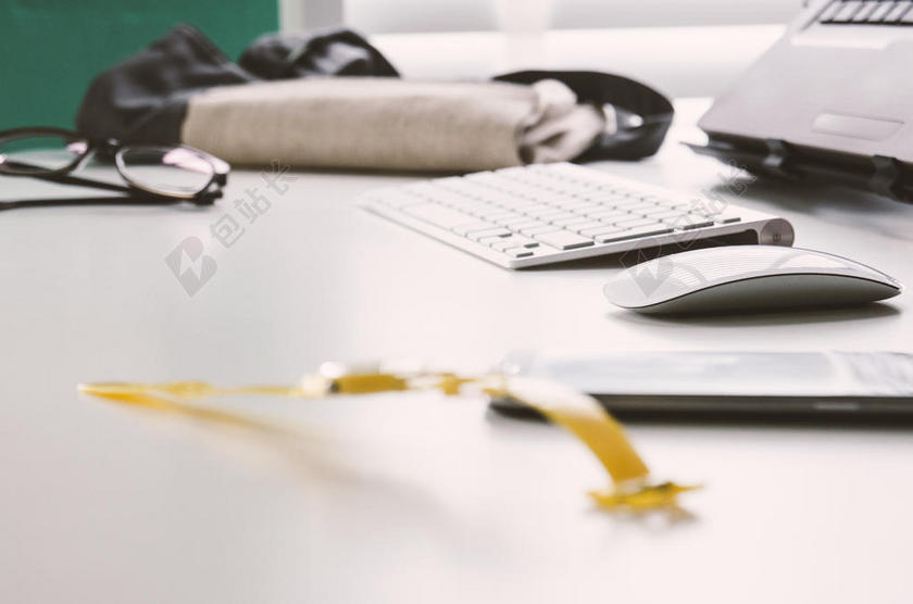 白色家居科技书桌上近景模糊手机计算机眼镜背景图片