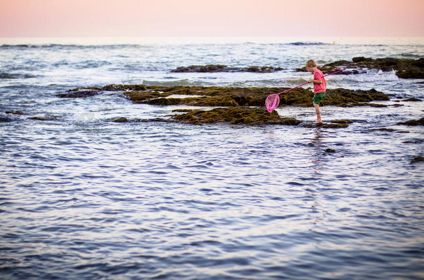 人物清新正在海面上捕捞的男孩儿童摄影大海背景图片