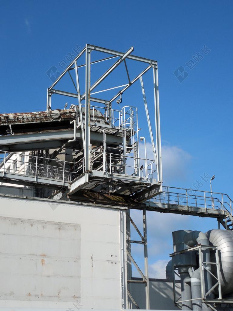 白蓝工业现代蓝天下的工厂一角工业生产背景图片