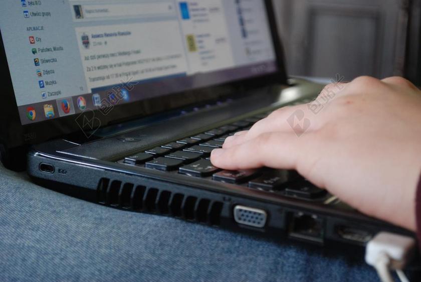 办公黑色键盘上的手背景图片