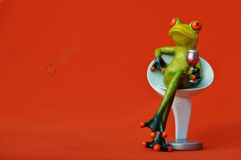 红色玩具舒适椅子上的喝酒青蛙模型背景图片