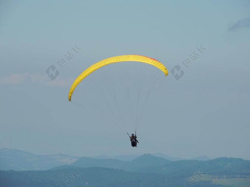 户外天空中的黄色滑翔伞和探险家背景图片