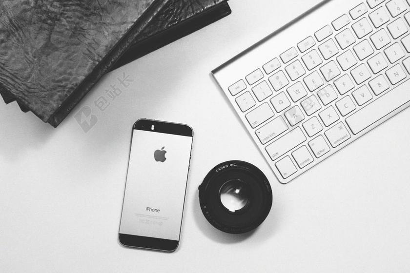 数码桌子上的苹果手机和镜头背景图片