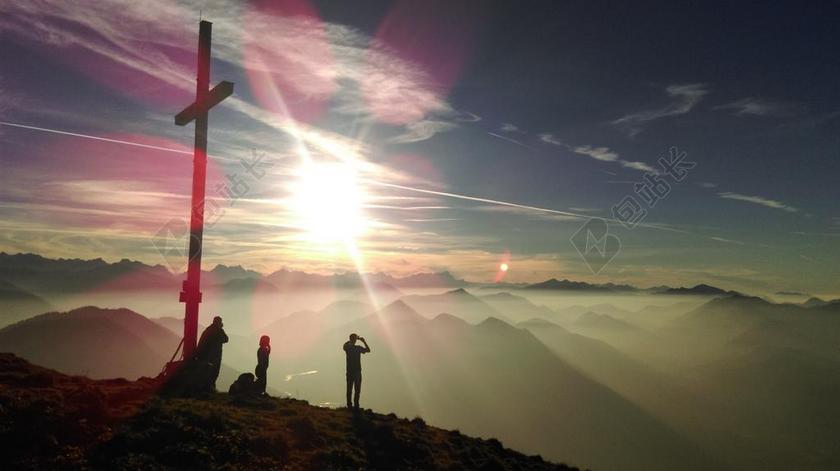 人物山顶的十字架和游客背景图片
