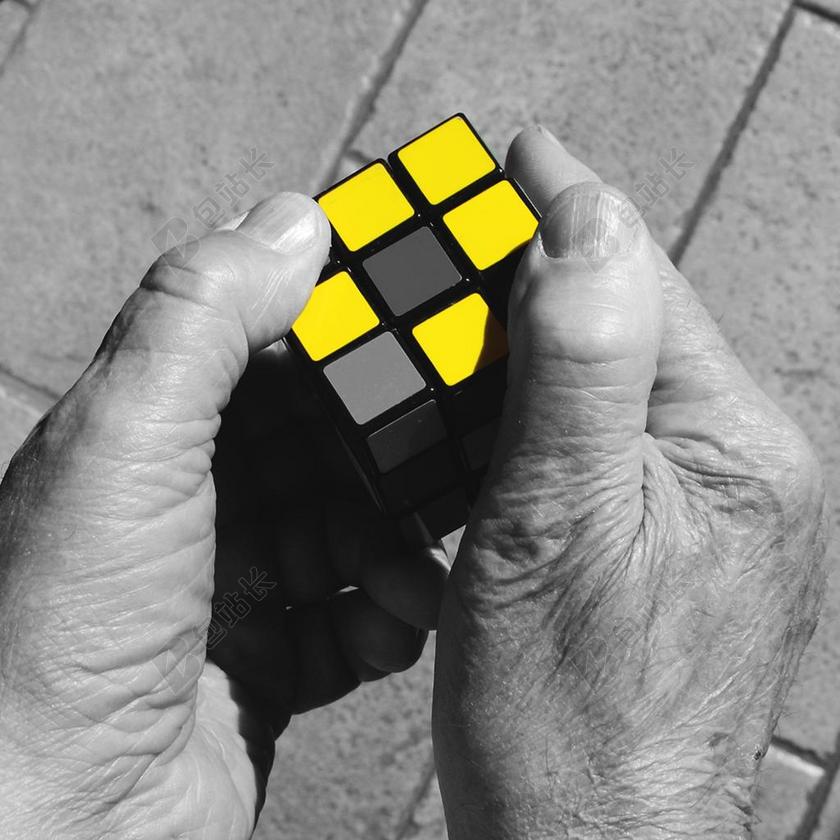 黄色广告魔幻显眼魔方被灰色大手摆弄宣传背景图片