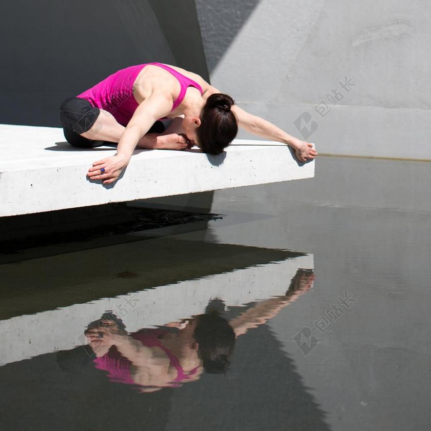瑜伽服女子池边表演瑜伽背景图片