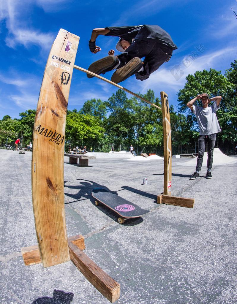 公园里的玩滑板青年背景图片