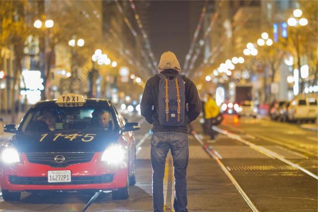 出租车背包男子夹克城市街道背景图片