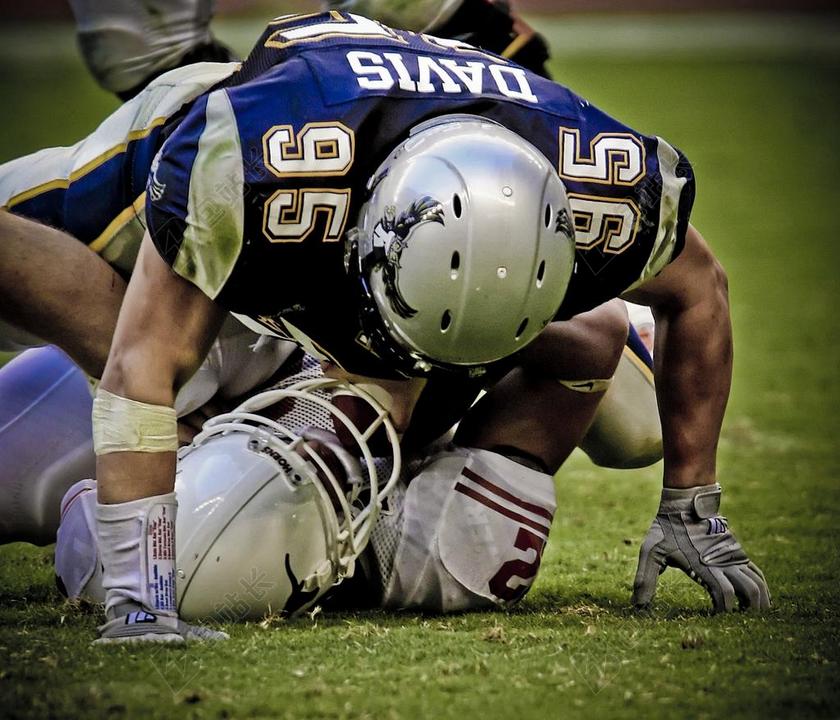 绿色草地上的橄榄球运动员背景图片