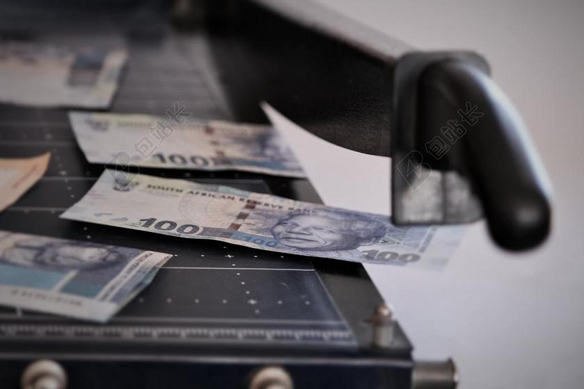 金融创意放在切割机上的钱币金钱切割交易商贸背景图片