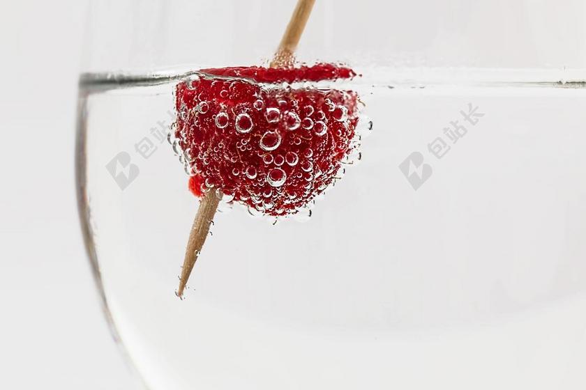 红白食物水果显现竹签插着樱桃在水中起泡樱桃水果饮料背景图片