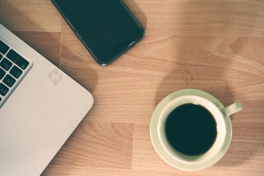 工作文艺木桌上的咖啡电脑手机等电子产品办公学习背景图片
