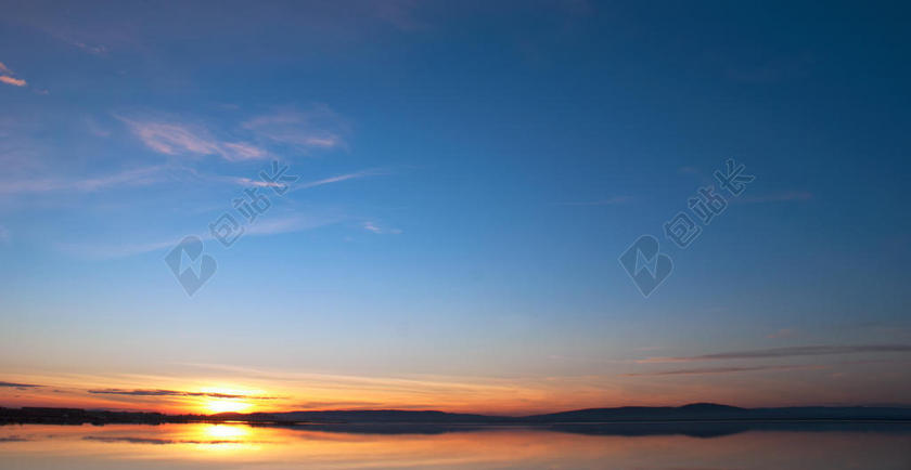 天边金色的云彩和蓝天背景图片