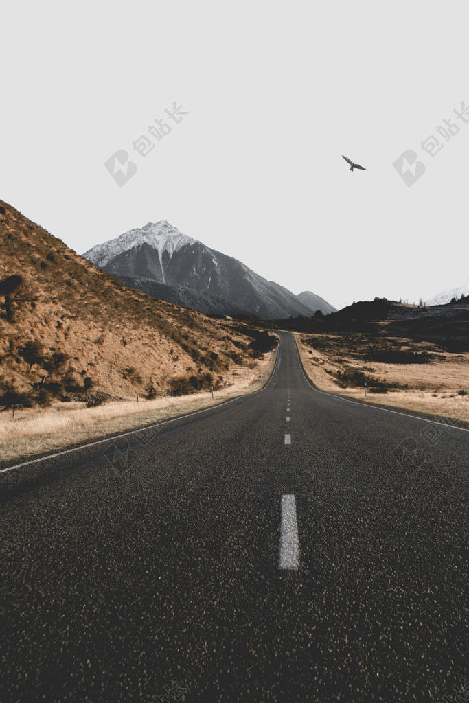 灰黄无尽野外山野间的柏油路公路背景图片