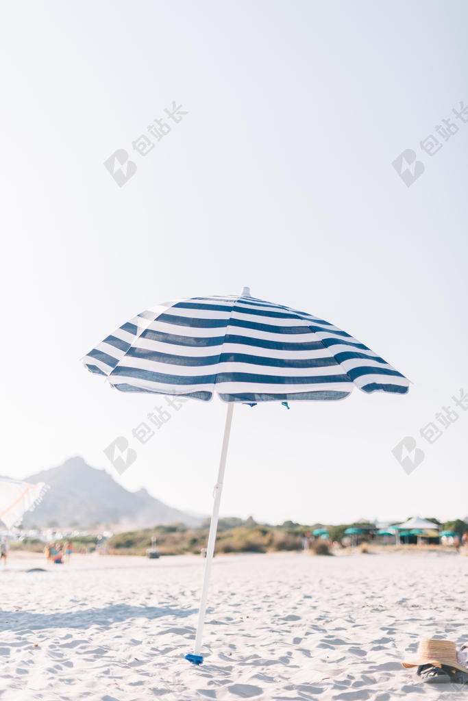 蓝白休闲清新蓝天下沙滩上的遮阳伞休闲旅游放松景点背景图片