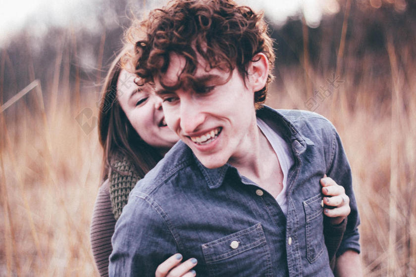 人温馨草地中玩耍的情侣背景图片