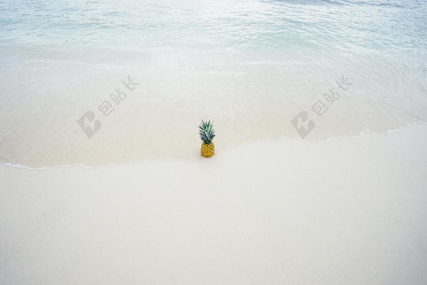 黄白食物清新海滩上的菠萝摆拍摄影水果背景图片
