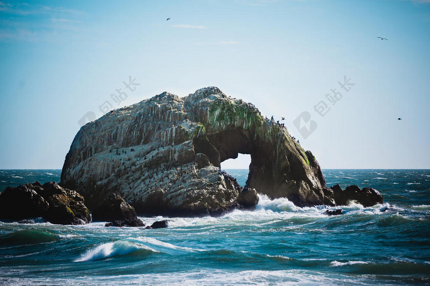 海面上黑色的礁石背景图片