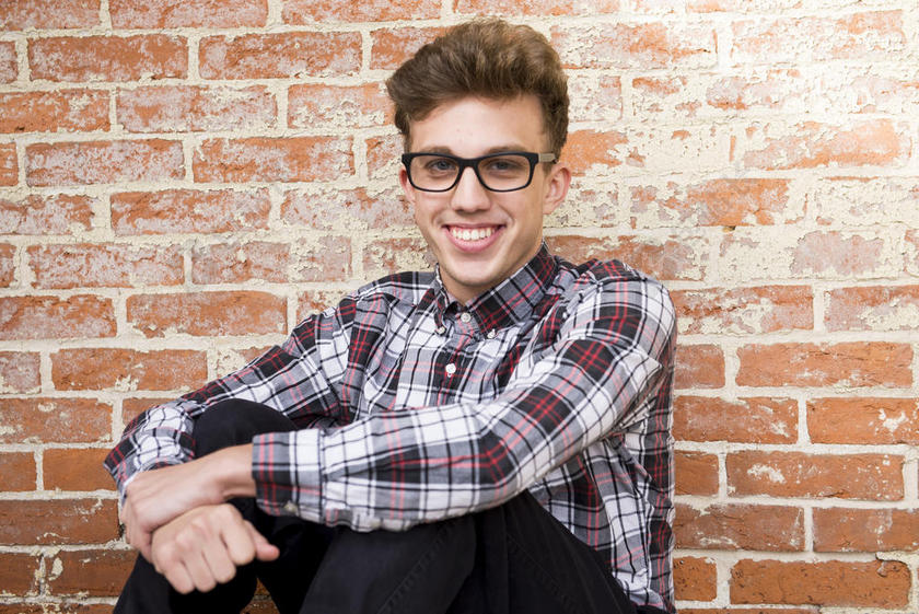 男孩 砖 砖 墙 随便的 可爱的 眼镜 眼镜 时尚 流行的 好看的 好看的 男人 人 肖像 坐 坐 微笑 微笑 风格 墙 穿 年轻的 青年