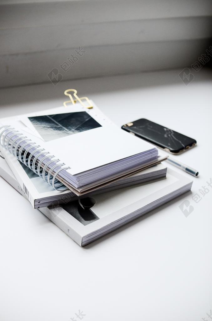 白色桌子上的笔记和手机背景图片