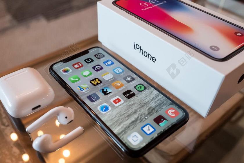 商务信息技术科技桌面放着IPHONEX 和苹果耳机背景图片