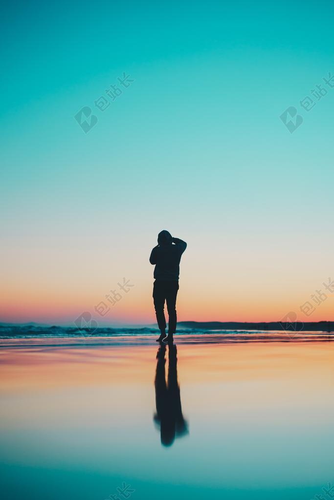 傍晚沙滩上的男人背影背景图片