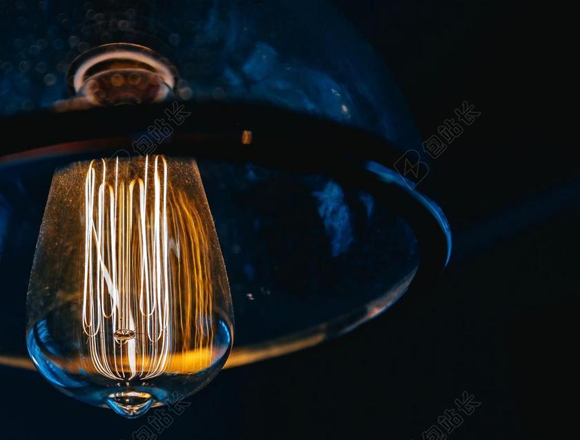 黑暗里的黄色灯泡背景图片