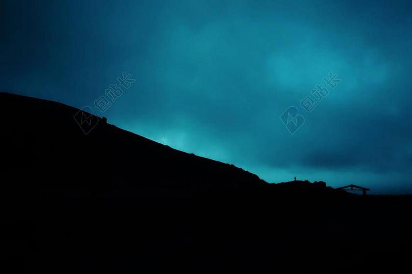 黑色的山丘和蓝天背景图片