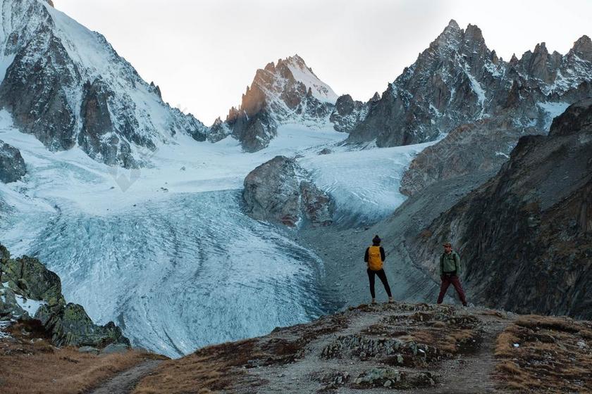 山坡上的探险者和雪山背景图片