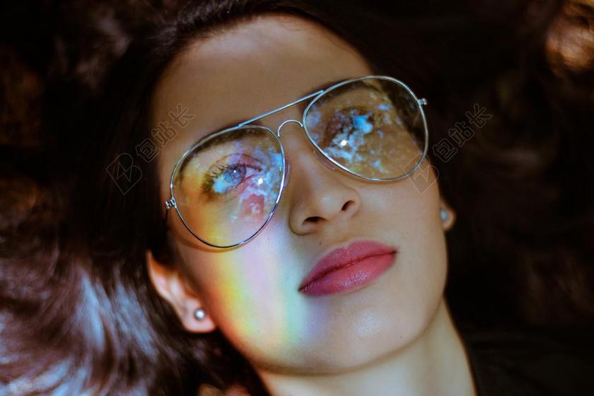 戴眼镜的女孩和彩虹背景图片