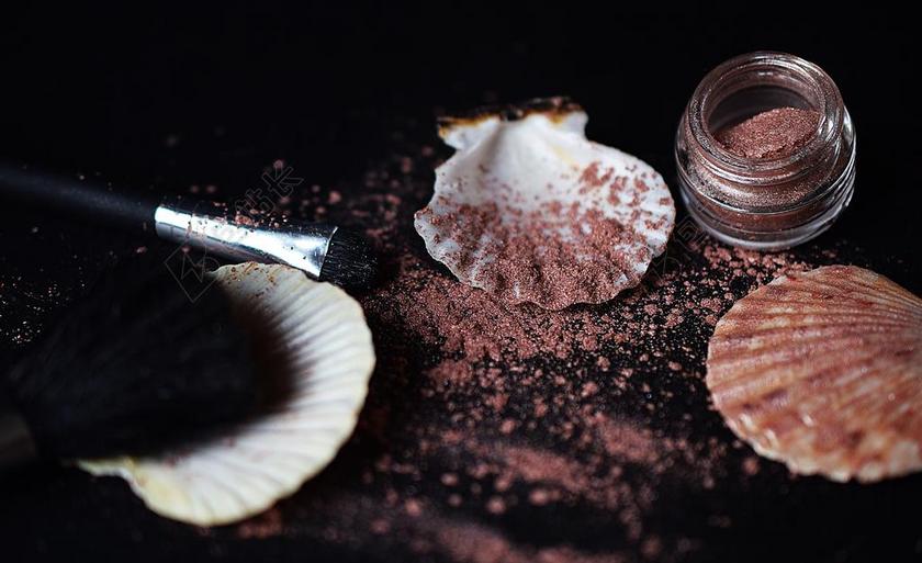 棕色的粉底和白色的贝壳背景图片