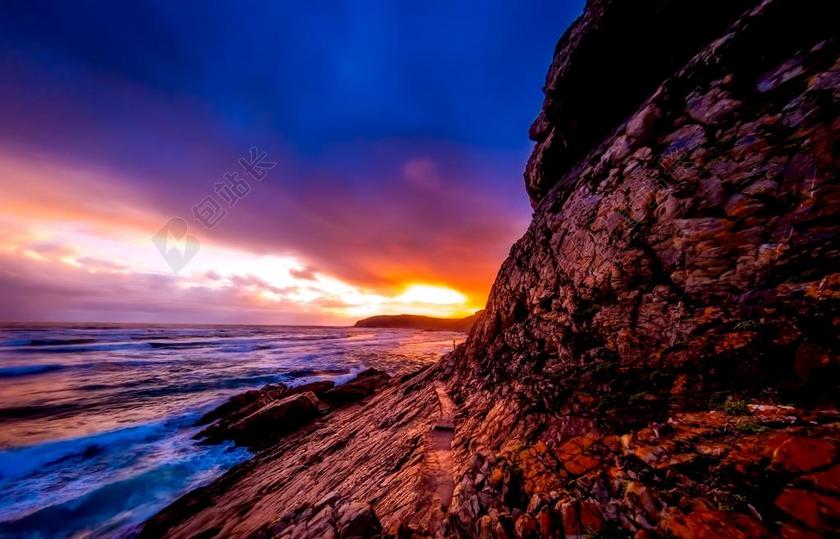 傍晚金色的夕阳和礁石背景图片