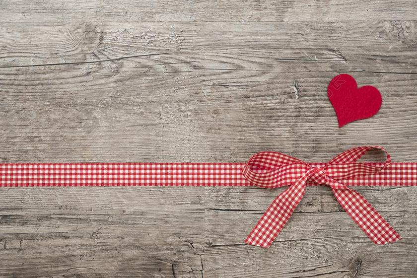 桌子上红色的丝带和红色的爱心背景图片