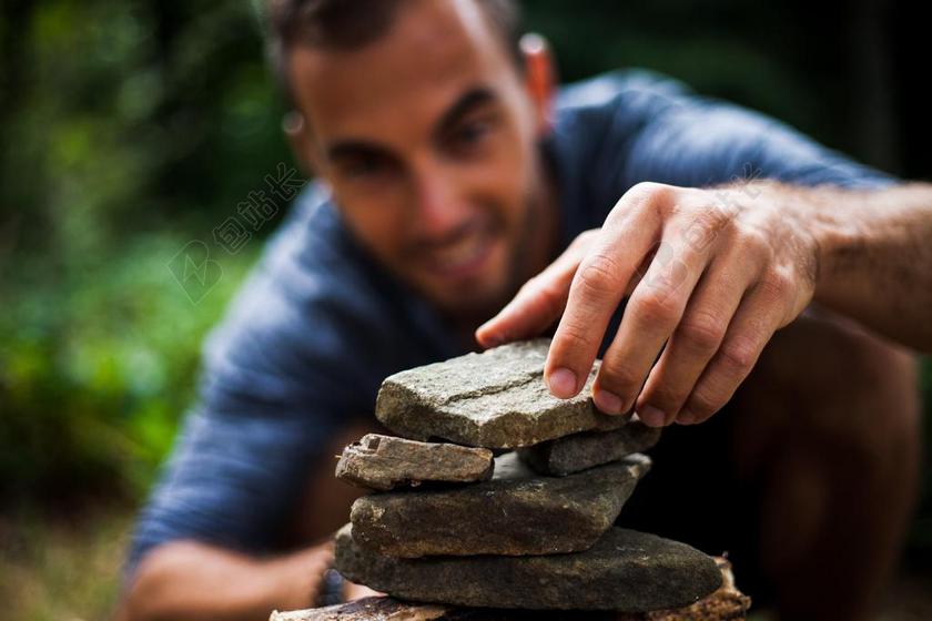 户外游戏休闲男人堆石头金字塔背景图片