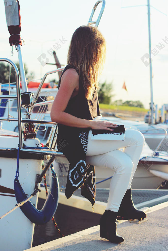 广告时尚夕阳下坐在岸边的金发女郎背景图片