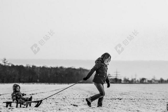 旅游清新雪地上母亲拖着女儿黑白照片背景图片