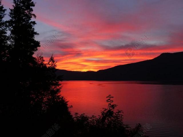 红色自然纹理夕阳下的远山和湖面背景图片
