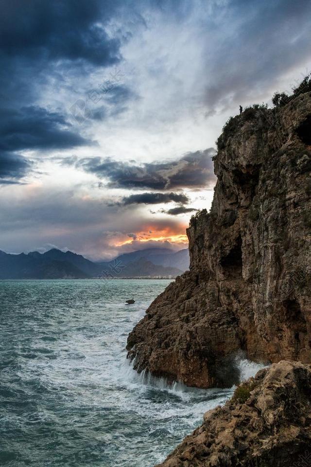 广告自然晚霞下海浪冲击岸边的石头背景图片