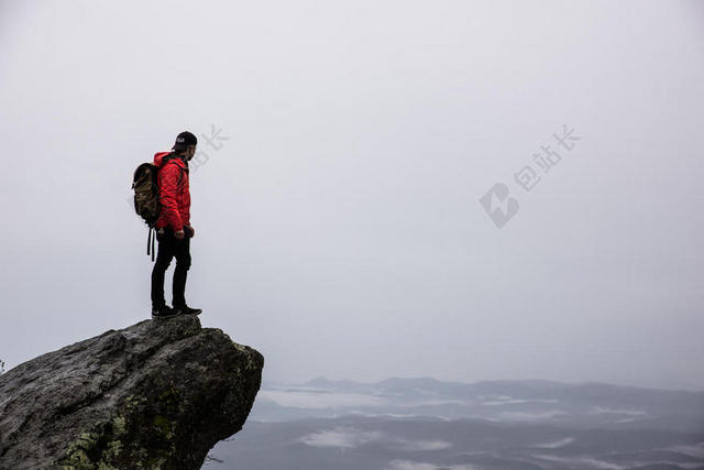 男人站在悬崖石头上背景图片