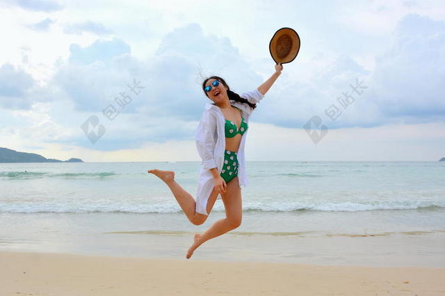蓝色休闲旅游度假女性穿着比基尼在海边跳跃背景图片