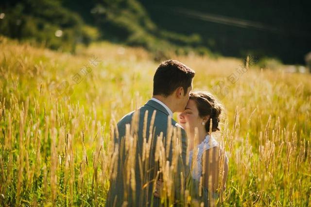 绿色婚庆温馨草中亲吻的夫妇背景图片