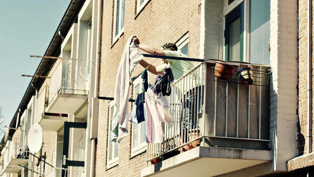 摄影简约阳台上晾晒衣服的女人背景图片