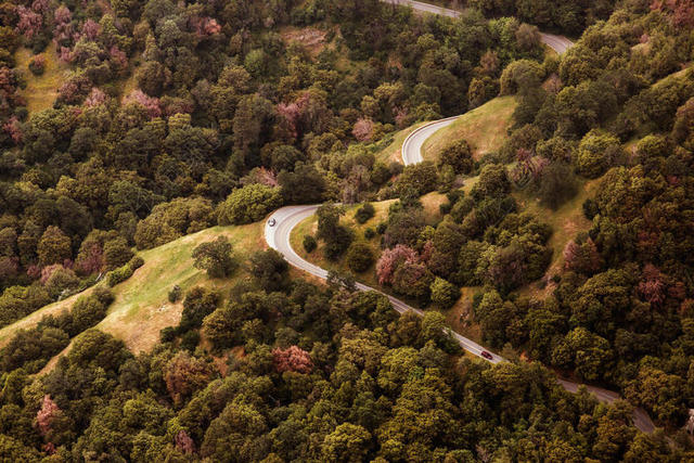 绿色自然清新群山之间一条盘山公路自然交通背景图片