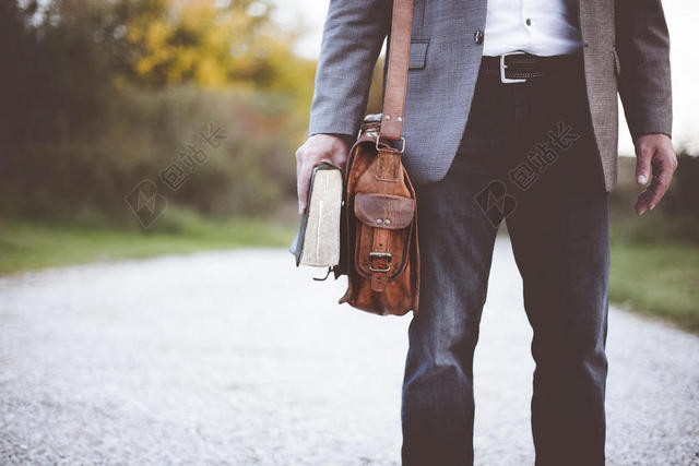 户外背包手拿书籍商务男士背景图片