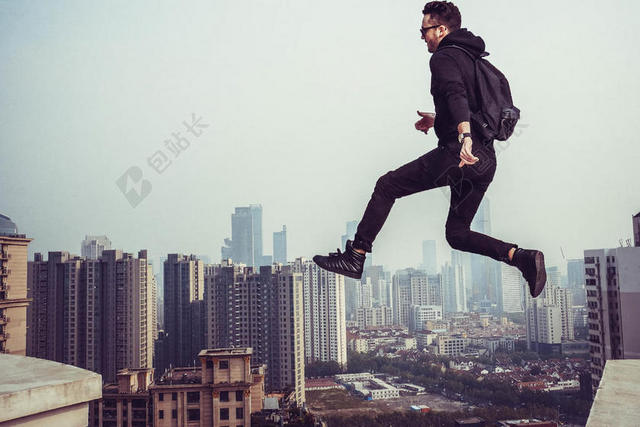 运动楼顶跳跃的男子背景图片