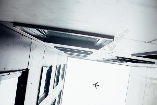 灰白现代城市建筑天空飞机背景图片