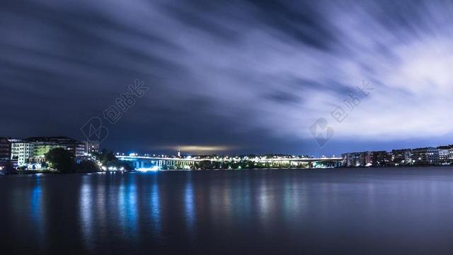 彩色黑色纹理宁静的海面和城市灯火背景图片