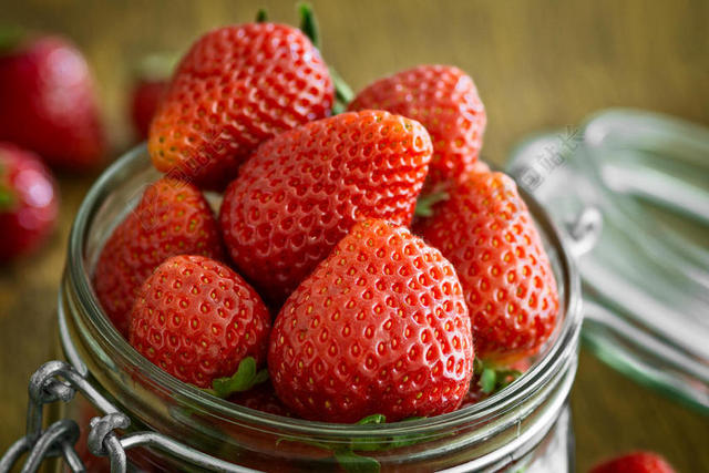 红色水果特写玻璃罐中的红色草莓背景图片